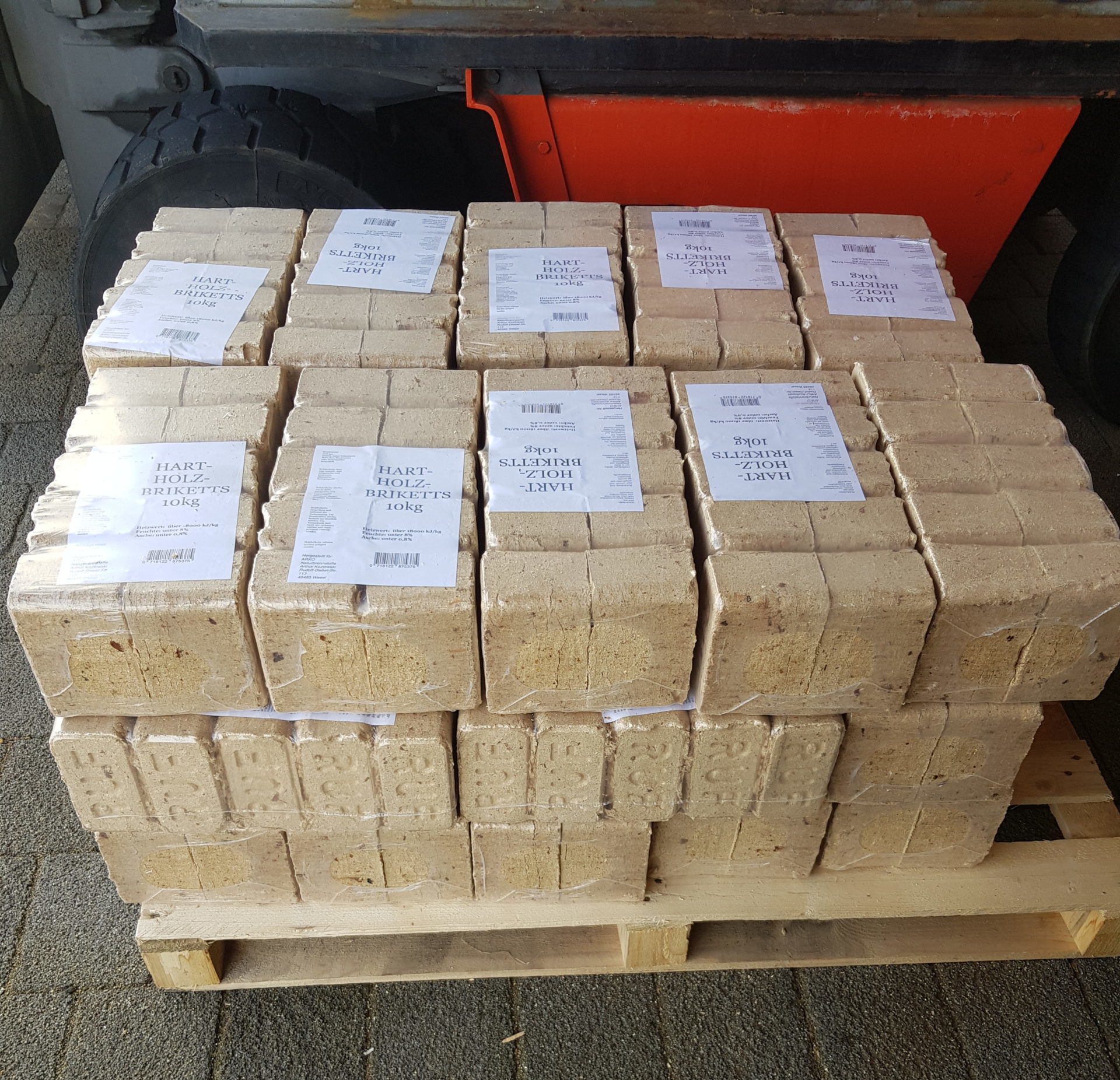 Palette mit quaderförmigen Hartholzbriketts a 10 kg – gestapelt und etikettiert