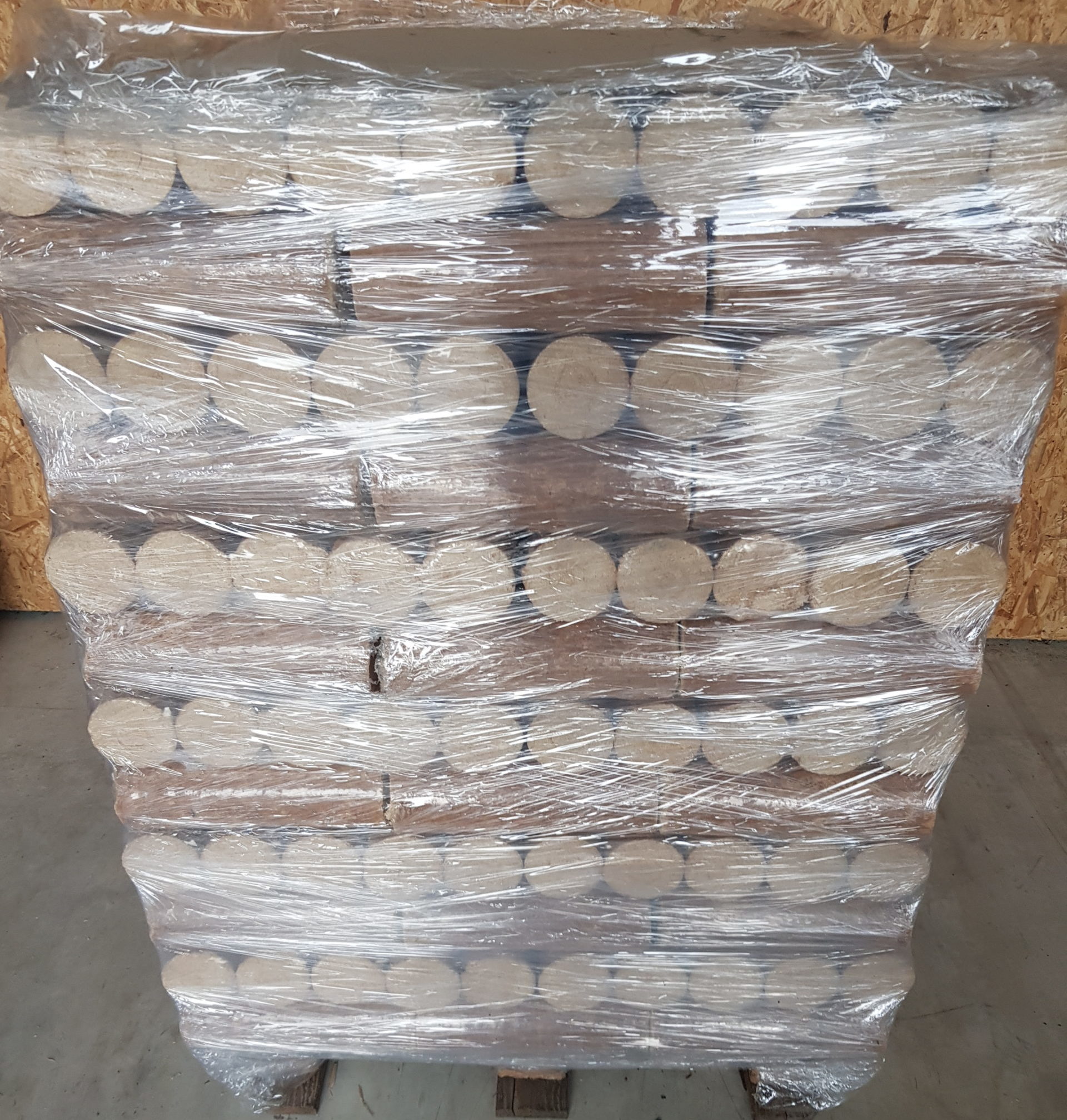 Palette mit verpackten Rundbriketts aus Holz – fertig für Auslieferung